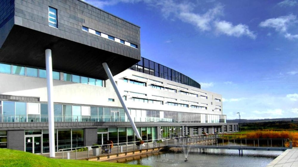 Das moderne Gebäude mit Glaswänden und ein Spiegelbecken sind auf dem Campus des St. Andrew's College zu sehen.