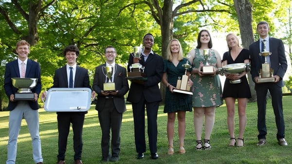 Eine Gruppe Schüler der St. Andrew's-Sewanee School steht im Freien und hält Auszeichnungen und Trophäen.