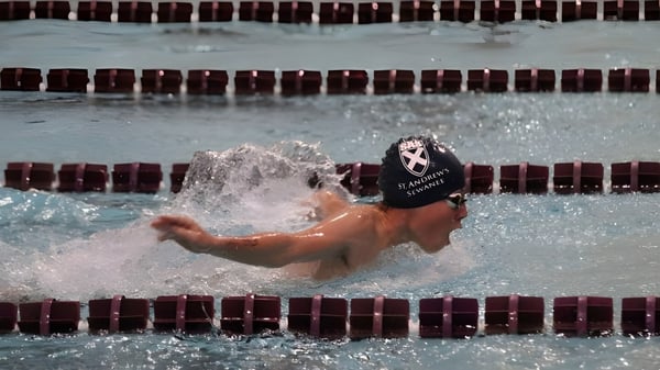 Ein Schwimmer der St. Andrew's-Sewanee School taucht in das Schwimmbecken und erzeugt eine Wasserspritzung.