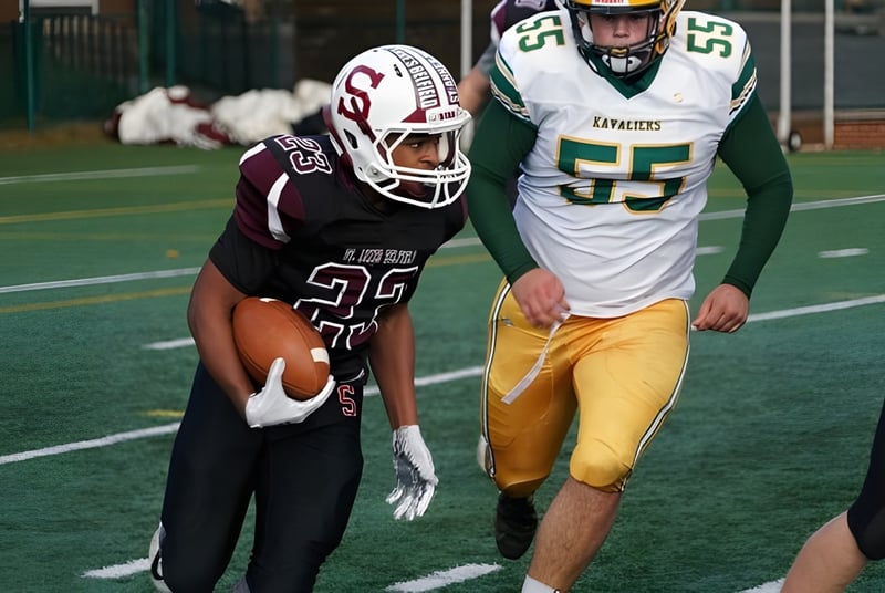 Zwei Footballspieler auf dem Spielfeld der St. Anne's-Belfield School kämpfen um den Ball vor dem Tor.