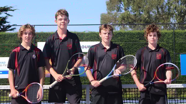 Vier Schülerinnen und Schüler von St. Bede's College stehen mit Tennisschlägern auf dem Tennisplatz.