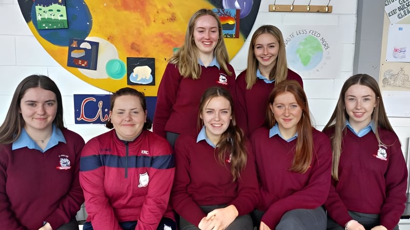 Eine Gruppe weiblicher Schülerinnen der St. Brendan’s Community School steht vor einem bunten Wandbild.