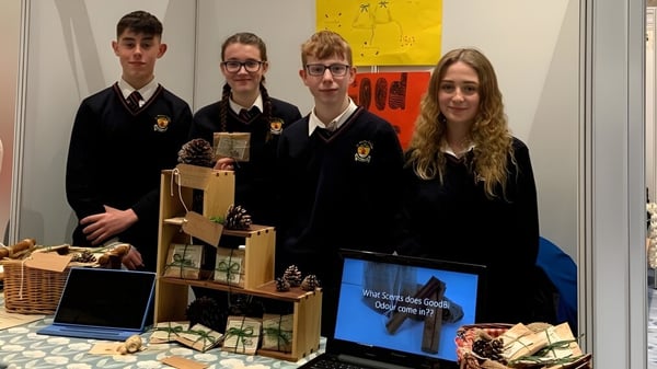 Schüler des St. Bricin’s College stehen vor einer Ausstellung mit Laptop und Körben.