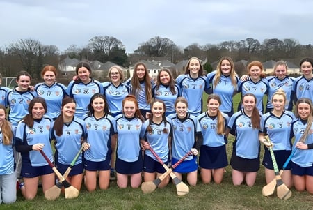 Eine Gruppe junger Sportlerinnen in hellblauen Uniformen steht auf einem Feld am St. Brigid's College.