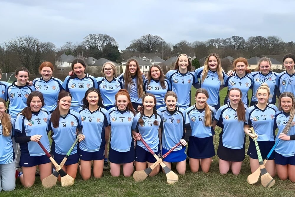 Eine Gruppe junger Sportlerinnen in hellblauen Uniformen steht auf einem Feld am St. Brigid's College.