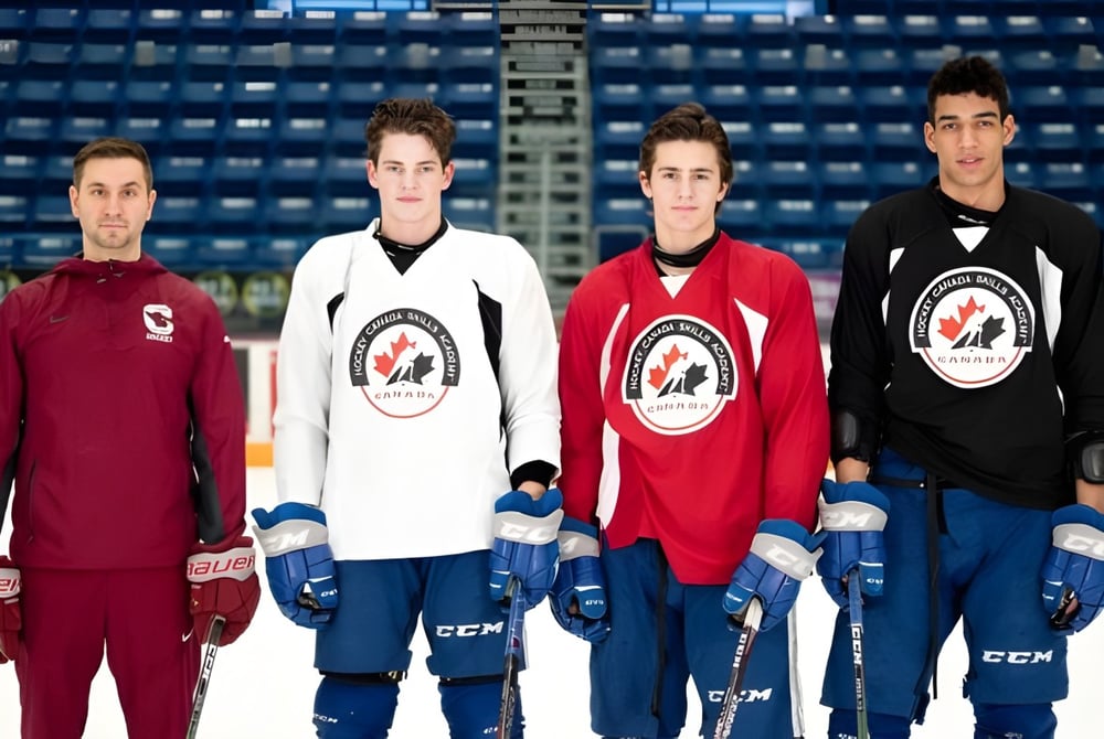 Vier Hockeyspieler stehen in Teamtrikots auf dem Eisfeld der Eishalle des St. Charles College.