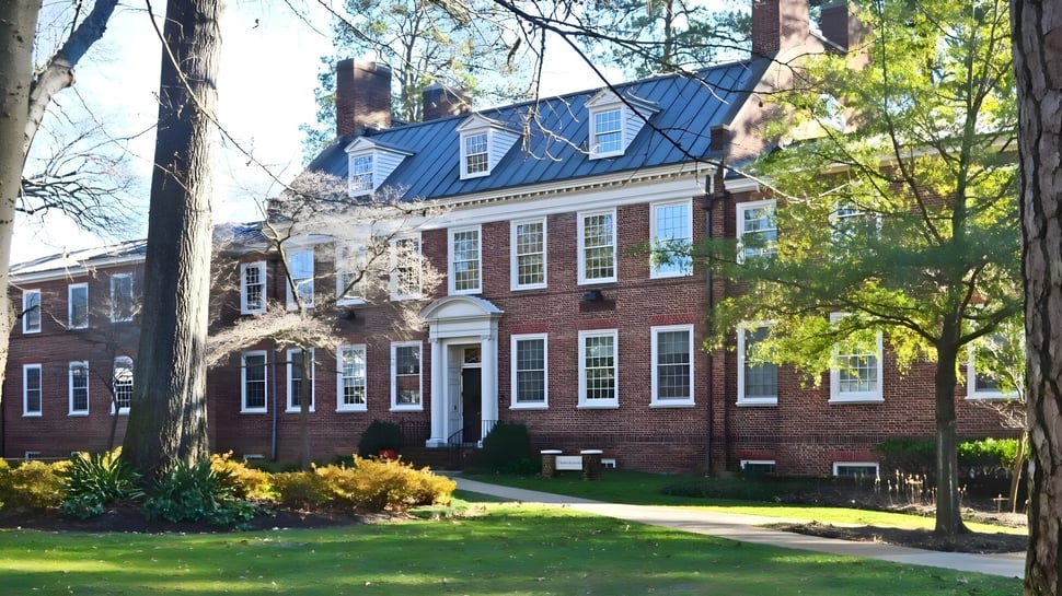 Das Backsteingebäude der St. Christopher’s School steht umgeben von Bäumen und gepflegtem Rasen.