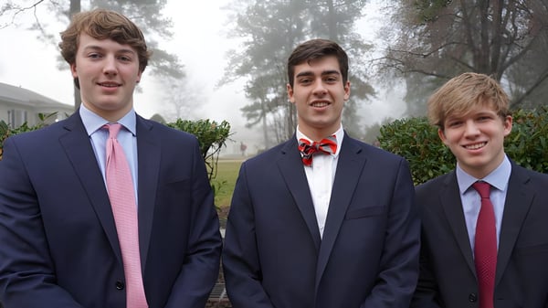 Drei Schüler der St. Christopher’s School stehen gemeinsam im Freien vor Bäumen und Grünflächen.