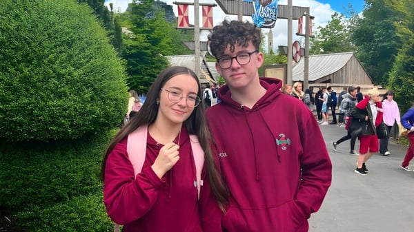 Zwei Personen stehen auf einer Straße mit verschiedenen Gebäuden im Hintergrund auf dem Gelände der St. Ciarán’s Community School.