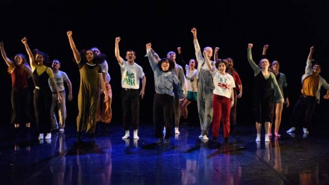 Schüler des St. Coleman's College stehen auf der Bühne und heben gemeinsam die Arme.