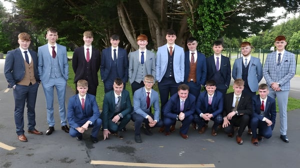 Eine Gruppe von Schülern des St. Coleman's College steht gemeinsam in einem parkähnlichen Bereich mit Bäumen im Hintergrund.