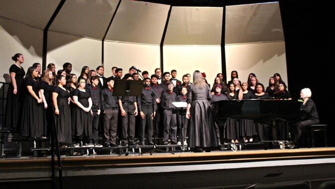 Ein großer Chor der St. Colmans College steht auf der Bühne und führt ein Musikstück auf.