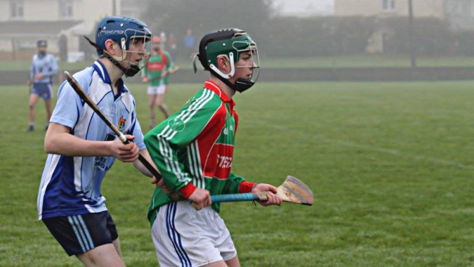Zwei Schüler des St. Colmans College in Sportkleidung stehen auf einem Sportplatz.