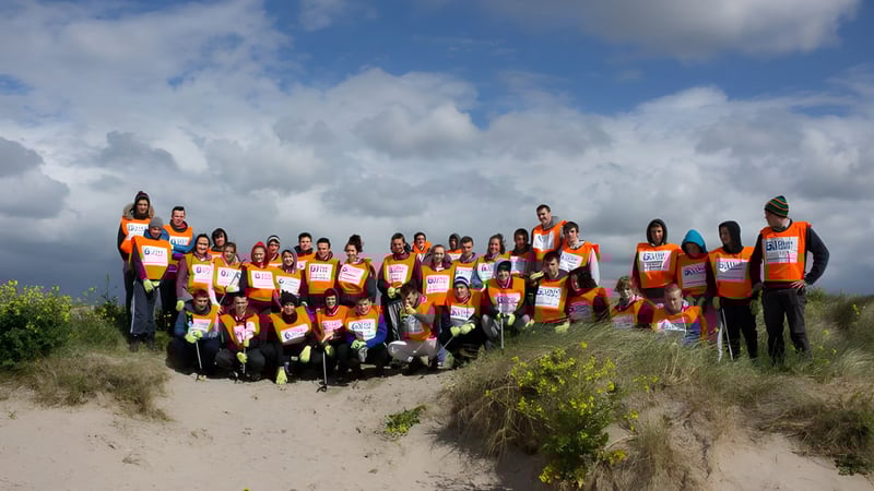 Eine Gruppe Schüler steht auf einem Feld und trägt orange Sicherheitswesten auf dem Gelände von St. Colman’s Community College.
