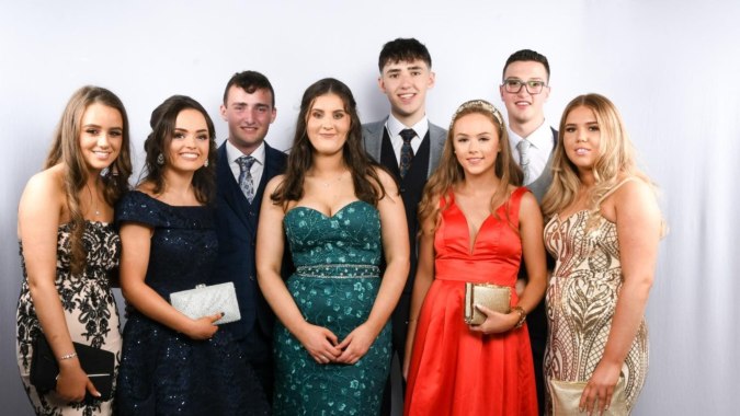 Eine Gruppe von gut gekleideten Schülerinnen und Schülern posiert auf einem Gruppenfoto am St. Columba's College vor weißem Hintergrund.