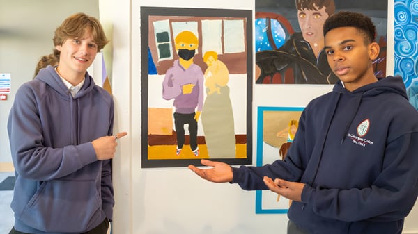 Zwei Schüler von St. Columba's College stehen vor einem bunten Gemälde an der Wand.