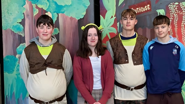 Vier Schüler stehen vor einem bunten Wandbild auf dem Campus des St. Cuan’s College.