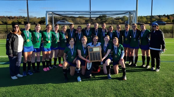 Eine Gruppe von Schülerinnen der St. David Catholic Secondary School steht auf dem Fußballfeld vor dem Tor.