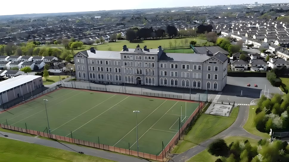 Das mehrstöckige Schulgebäude der St. David's C.B.S. mit einem Sportfeld und einer Rasenfläche im Vordergrund in einem Wohngebiet.