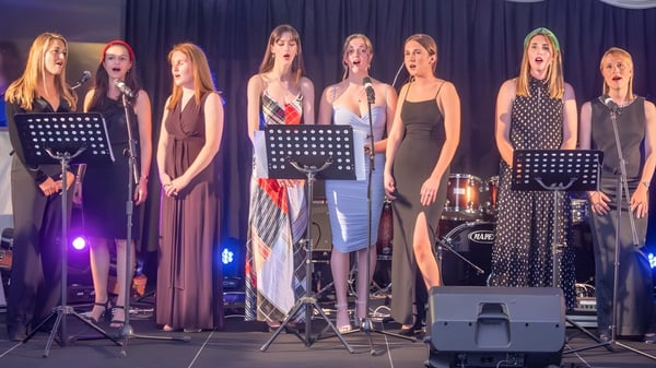 Eine Gruppe Frauen führt mit Musikinstrumenten auf der Bühne beim St. David’s College auf.