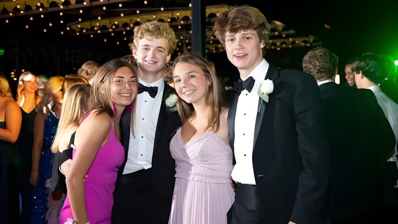 Eine Gruppe gut gekleideter Schülerinnen und Schüler posiert vor funkelnder Beleuchtung auf dem Empfang des St. David's Catholic Sixth Form College.