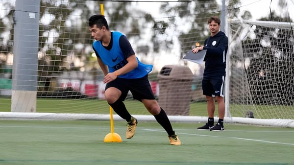 Eine Schülerin vom St. David’s College dribbelt einen Fußball auf einem Rasenfeld mit einer weiteren Schülerin im Hintergrund.