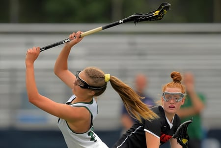 Zwei Schülerinnen spielen Hockey auf dem Spielfeld des St. Dominic’s College.