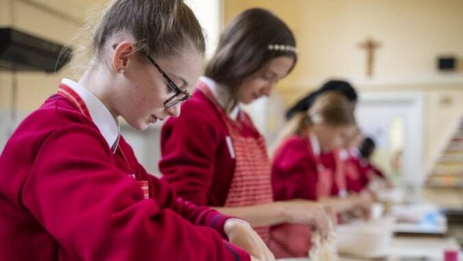 Schüler in roten Uniformen nehmen an einer Aktivität im Unterricht am St. Dominic’s College teil.