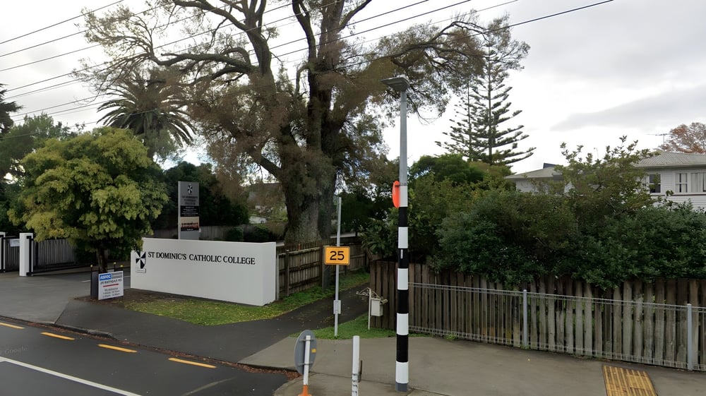 Der Eingang zum Campus von St. Dominic's Girl’s Catholic College mit einem Schild und umliegendem Grün.