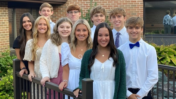Eine Gruppe Schülerinnen und Schüler posiert vor einem Backsteingebäude auf dem Gelände der St. Edmond Catholic School.