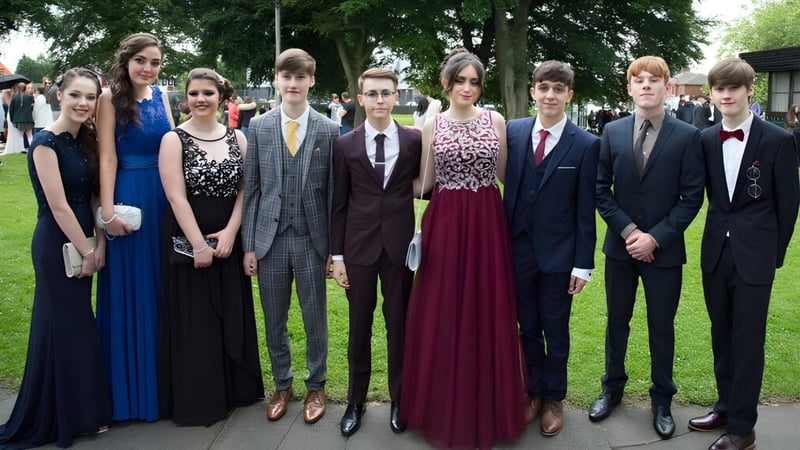 Eine Gruppe gut gekleideter Schülerinnen und Schüler steht gemeinsam im Park des St. Edmund’s College.