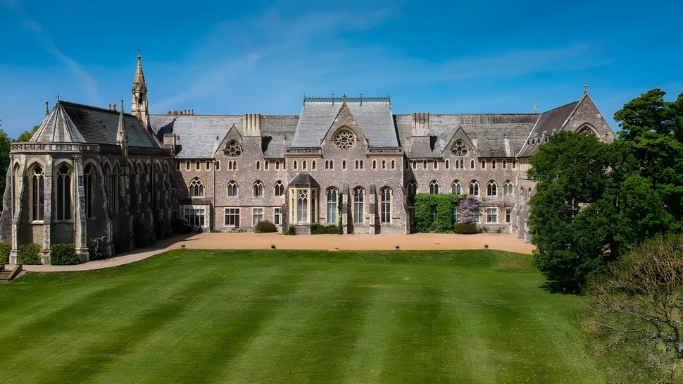 Das gotische Hauptgebäude der St. Edmunds School mit detaillierter Architektur vor blauem Himmel.