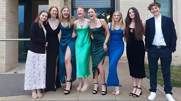 Eine Gruppe von Schülern der St Edward's School Oxford steht in formeller Kleidung vor einem modernen Gebäude und posiert für ein Foto.