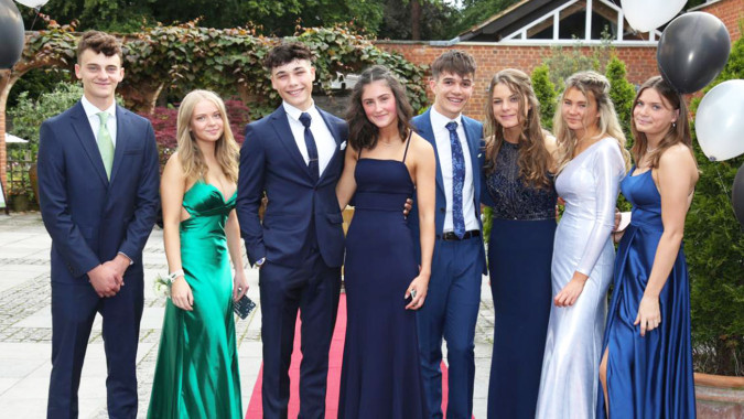 Eine Gruppe von Personen steht vor einem Backsteingebäude auf dem Campus der St. Edward's School in Poole.