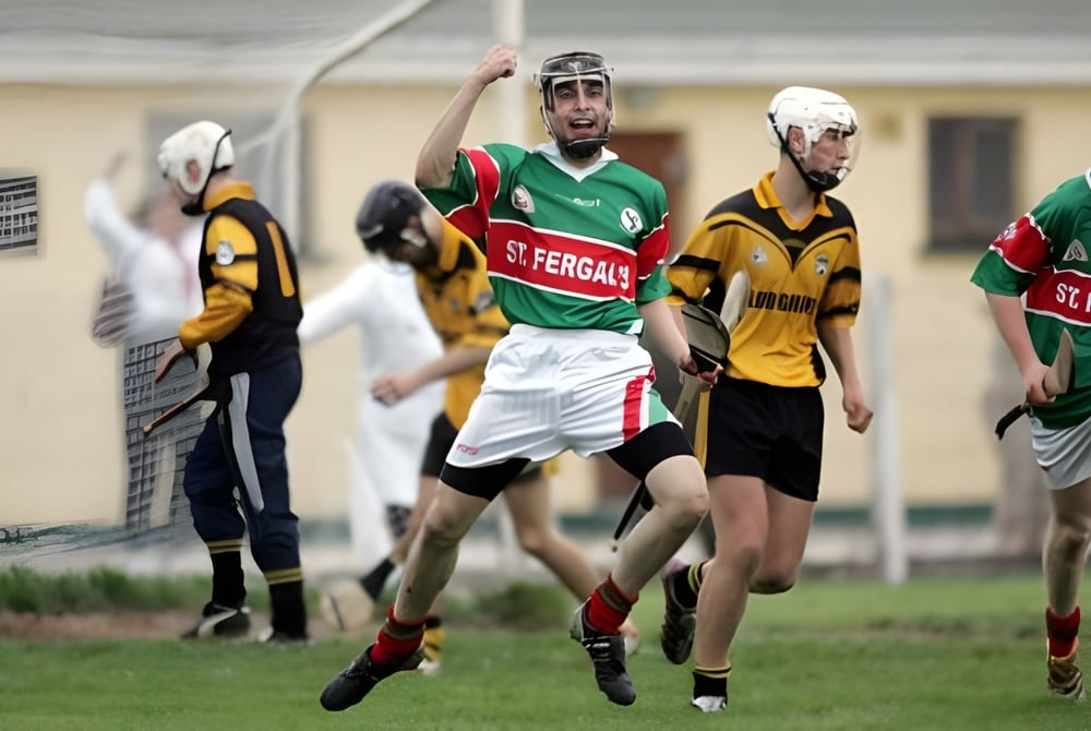 Eine Gruppe Schüler spielt Hurling auf dem Sportfeld von St. Fergal’s College mit Gebäuden im Hintergrund.
