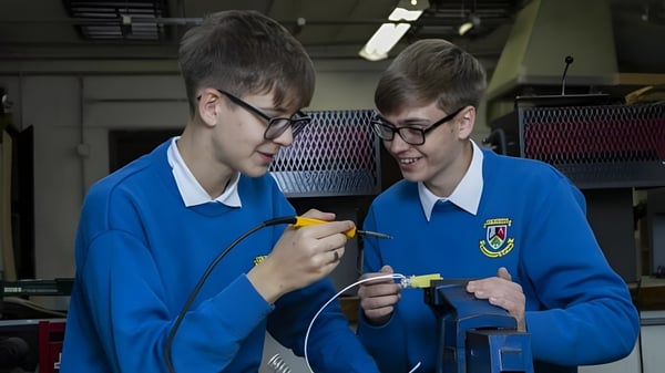 Zwei Schülerinnen und Schüler des St. Finian’s Community College untersuchen gemeinsam etwas in einem Labor.