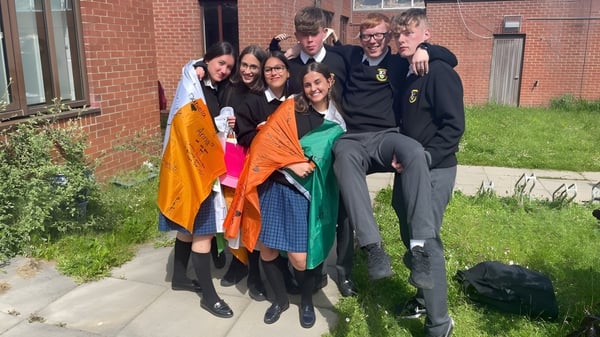 Eine Gruppe Schüler steht auf einer Wiese vor einem Backsteingebäude auf dem Gelände von St. Finian’s Community College.