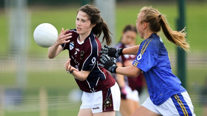 Zwei Schülerinnen des St. Finian’s Community College kämpfen auf dem Rugbyfeld um den Ball.