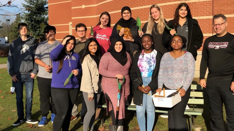 Eine Gruppe Schülerinnen und Schüler steht vor einem Backsteingebäude auf dem Gelände der St. Francis Xavier High School.