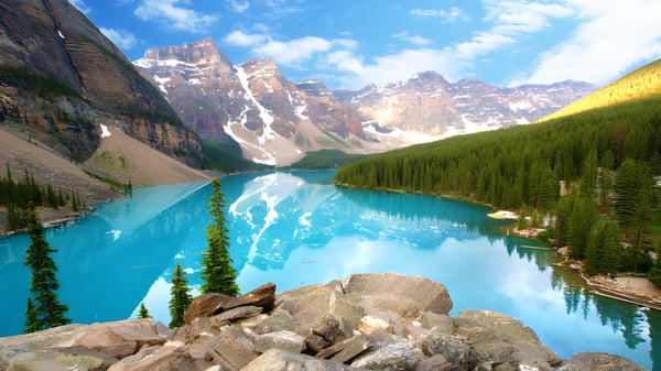 Ein alpiner See mit türkisfarbenem Wasser und schneebedeckten Bergen im Hintergrund zeigt die Naturlandschaft nahe der St. George’s School.