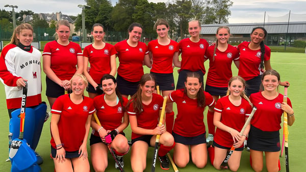 Eine Gruppe junger Athletinnen in roten Trikots steht auf dem Sportfeld der St. George's School in Edinburgh.