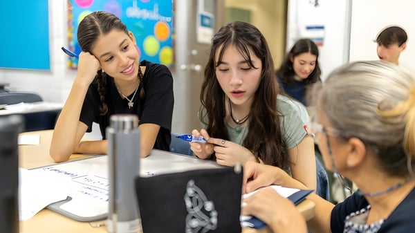Eine Gruppe von Schülern arbeitet gemeinsam an einem Projekt in einem Klassenraum der St. George's School of Montreal.