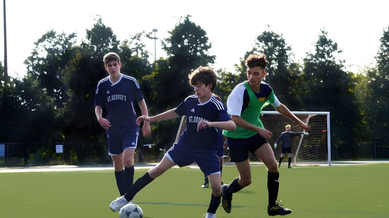 Drei Schülerinnen und Schüler spielen Fußball auf einem Rasenfeld auf dem Gelände der St. George's School of Montreal.