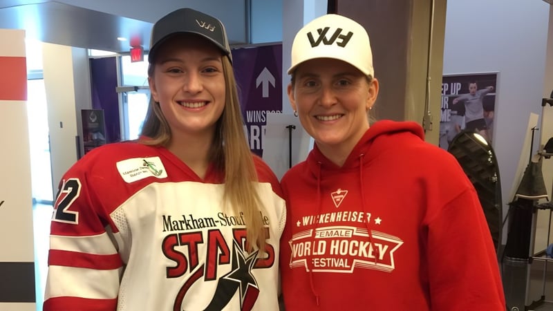 Zwei Schülerinnen oder Schüler der St. James' Regional High tragen Sporttrikots und Hüte in einem Flur.