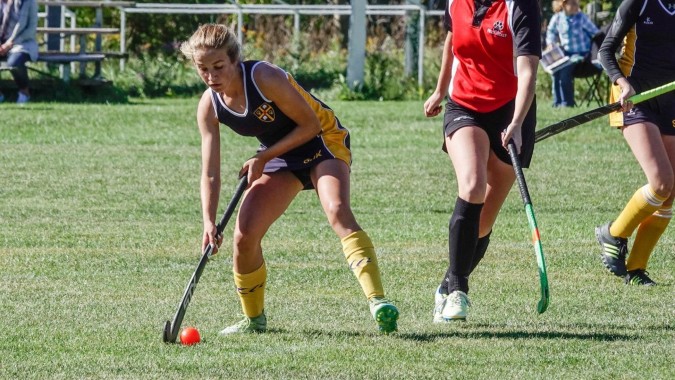 Schüler der St. John’s-Kilmarnock School spielen gemeinsam einen Feldsport auf dem Sportplatz.