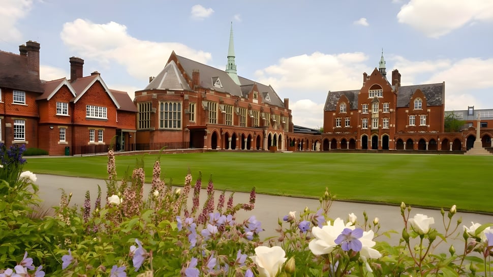 Das historische Backsteingebäude mit hohem Turm auf dem grünen Gelände der St. John’s School in Leatherhead.