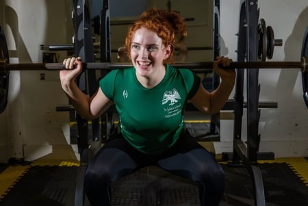 Eine Person hebt Gewichte im Fitnessraum der St. John’s School in Leatherhead.