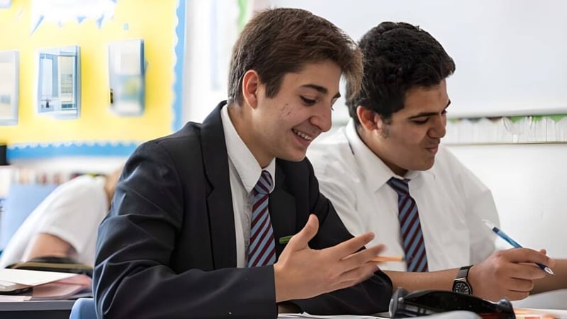 Zwei Schüler der St. John’s School Sidmouth arbeiten gemeinsam an einer Aufgabe am Schreibtisch.