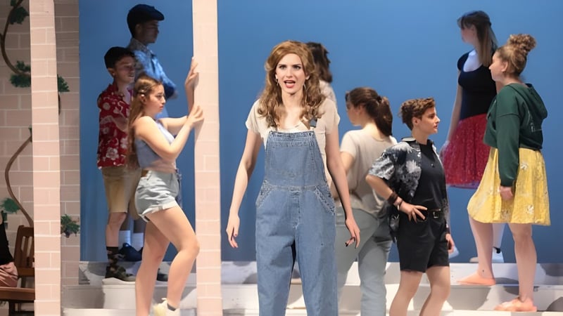 Eine Gruppe Schülerinnen und Schüler steht vor blauem Hintergrund auf dem Campus der St. Johnsbury Academy.