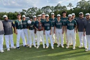 Eine Gruppe von Baseballspielern in Uniformen steht auf dem Spielfeld der St. Joseph Academy.